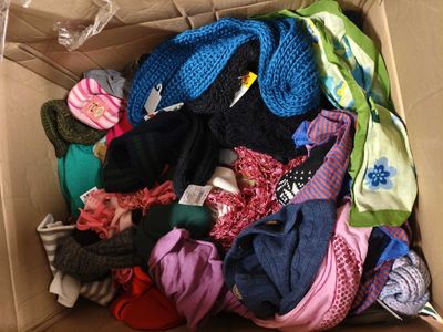 une boîte en carton remplie de vêtements de toutes les couleurs