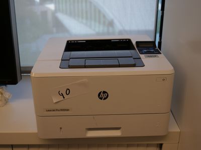 une imprimante posée sur un bureau, à côté d'un écran