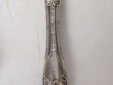 a silver spoon and a knife on a white table