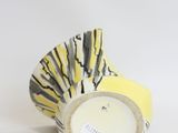 yellow and white vase with a black and white design on it