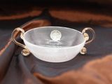 a glass bowl that is sitting on a brown cloth