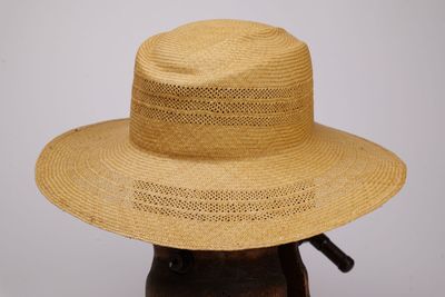 une image représentant un chapeau de paille posé sur une tête de mannequin