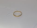 une bague en or posée sur une table blanche, attachée à un fil