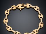 gros plan d'un bracelet en chaîne en or sur fond noir