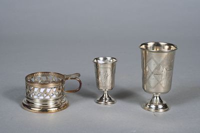 two silver cups and a silver cup on a table