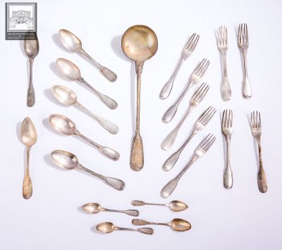 a lot of silver spoons and forks laid out on the table