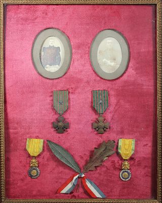 une photo d'un cadre contenant des médailles et d'autres objets