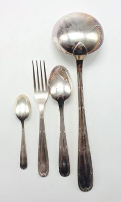 une cuillère, une fourchette et un repose-cuillère posés sur une surface blanche