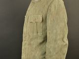 a green jacket on a mannequin stand against a black background