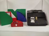 a black briefcase sitting on a white shelf next to a red and green box