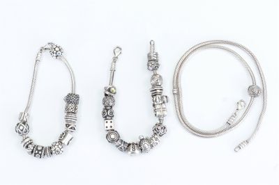 three silver bracelets and a necklace on a white background