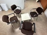 quatre chaises et une table disposées en cercle sur le sol