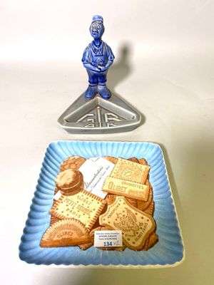 une assiette bleue sur laquelle sont posés des biscuits, à côté d'une assiette bleue sur laquelle se trouve une petite figurine représentant un homme