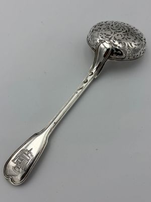 une cuillère dans laquelle se trouve une autre cuillère, posée sur une table
