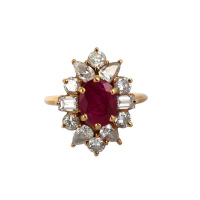 gros plan d'une bague avec une pierre rouge entourée de diamants blancs