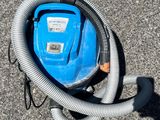 une photo d'un aspirateur bleu posé par terre