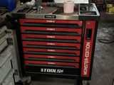 une boîte à outils posée dans un garage, avec des outils dessus