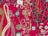many different types of necklaces and bracelets in a display case