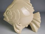 un petit poisson en céramique posé sur une table