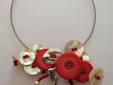 un collier composé de boutons et de perles sur un fond blanc