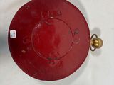 a red clock on a white table with a gold ball