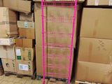 a pink rack with a pink handle in front of a pile of boxes