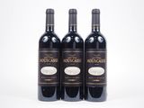 trois bouteilles de vin rouge posées l'une à côté de l'autre sur une surface blanche