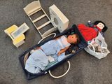 un bébé allongé dans une valise à côté d'une poupée