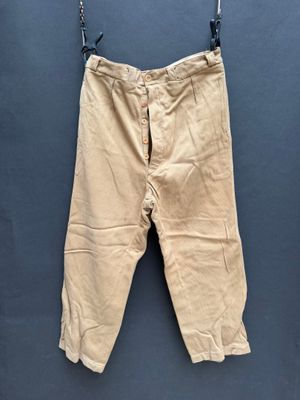 un vieux pantalon suspendu à une corde à linge fixée au mur