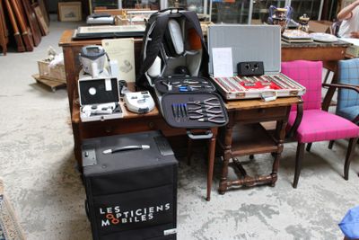un bureau sur lequel se trouvent un ordinateur portable, une valise et d'autres objets