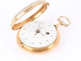 a gold pocket watch sitting on a white surface