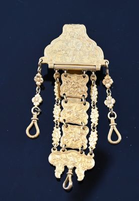 une image représentant un collier en or dont la chaîne pend sur le côté