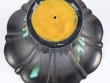 a yellow candle that is sitting on a black plate