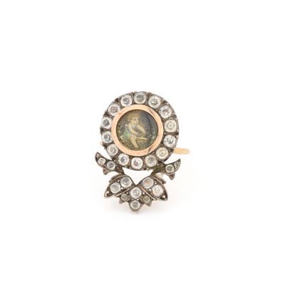un gros plan d'une bague en diamant et en or sur fond blanc