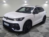 un SUV Volkswagen blanc garé sur un sol à damier dans un garage