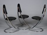 pair of chrome plated chairs with black leather seat covers