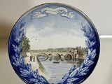 a blue and white plate with a picture of a bridge on it
