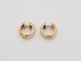 a pair of gold and diamond hoop earrings on a white surface