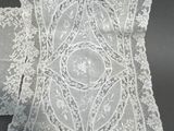 a close up of a pair of white lace pillows on a table