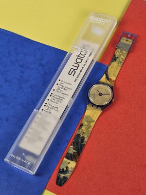 a watch sitting on top of a piece of paper next to a pen