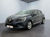 Une voiture grise est garée dans une pièce aux murs blancs.