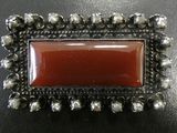 an image of a picture of a red stone in a silver frame