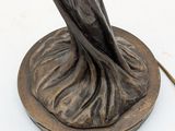 a statue of a woman holding a bird on top of a table
