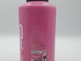 a bottle of pink paint sitting on a white surface