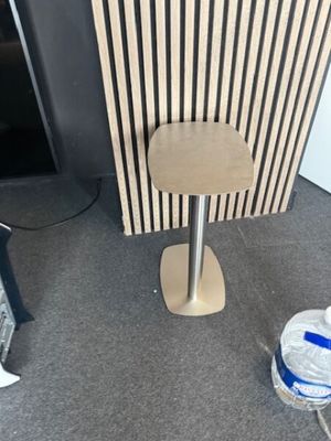 une petite table sur laquelle est posé un tabouret, dans une pièce