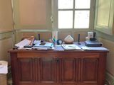 un bureau dans une pièce dotée d'une fenêtre, sur lequel sont empilés de nombreux papiers