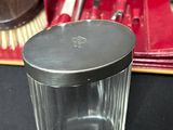 a small glass jar with a metal lid on a table