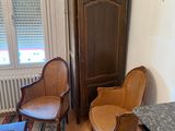 a small living room with a chair and a cabinet in it