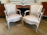 une paire de chaises anciennes de style français devant une cheminée