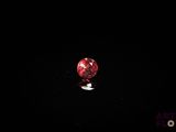 une image représentant un diamant rouge posé sur une surface noire